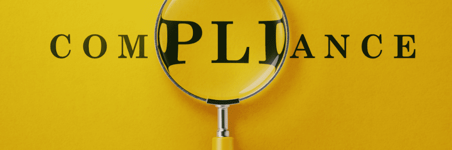 A magnifying glass over the text COMPLIANCE