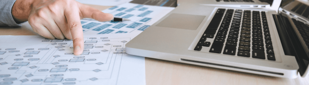 A desk with diagrams and a laptop